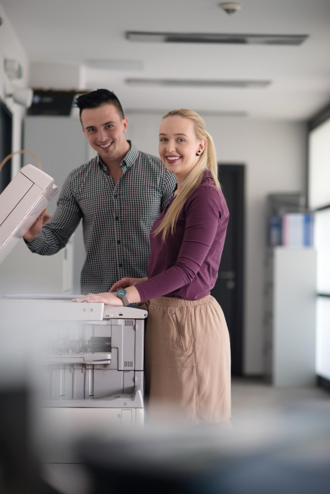 Ventajas de las multifuncionales Ricoh para oficinas modernas EMPLEADOS SACANDO FOTOCOPIAS
